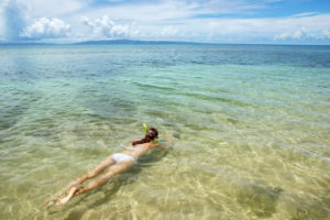 Young woman snorkeling in clear water on Taveuni Island, Fiji