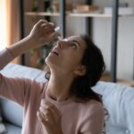 Woman using eye drops