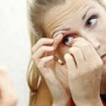 Woman putting in contact lens