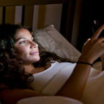 Woman looking at her phone in a dark room