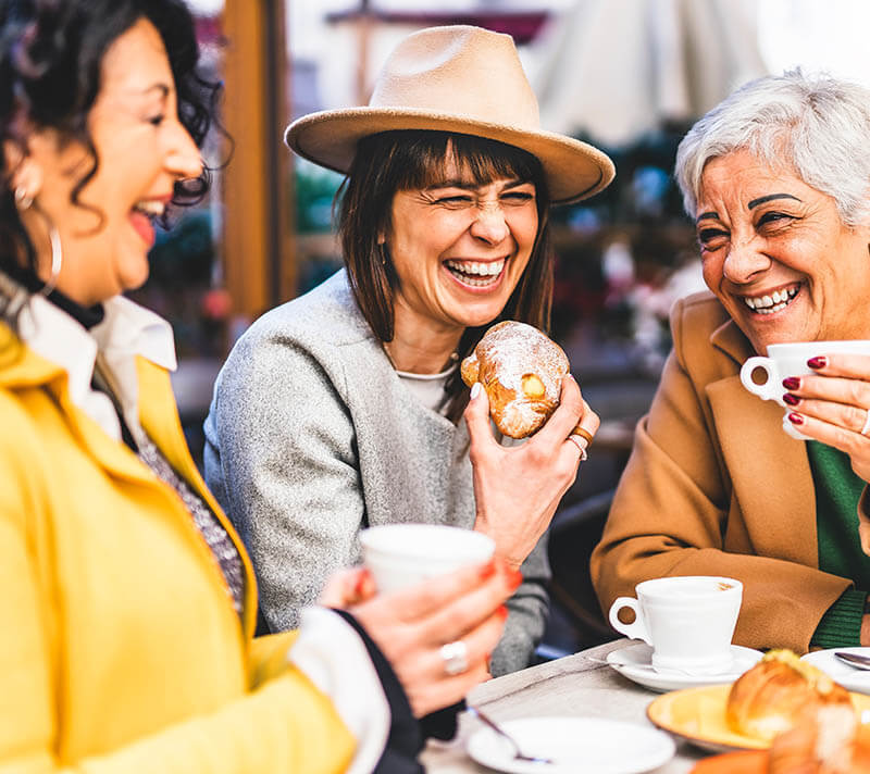 Friends Laughing while eating breakfast at a restaurant