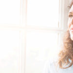 Woman sitting by a window in thought