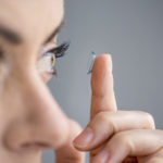 woman in her forties inserting contact lenses